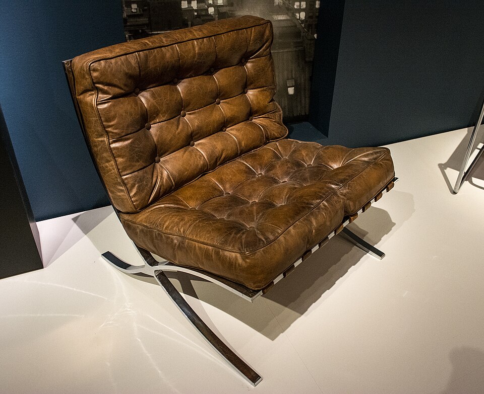 A Barcelona Chair showing its X-shaped chrome frame and tufted leather cushions